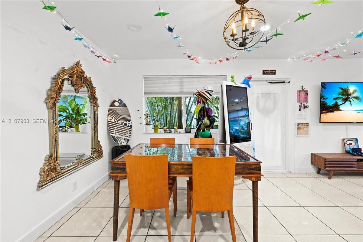 Interior space featuring large-format tile flooring, a statement orb chandelier, and a wide window with integrated roller shade