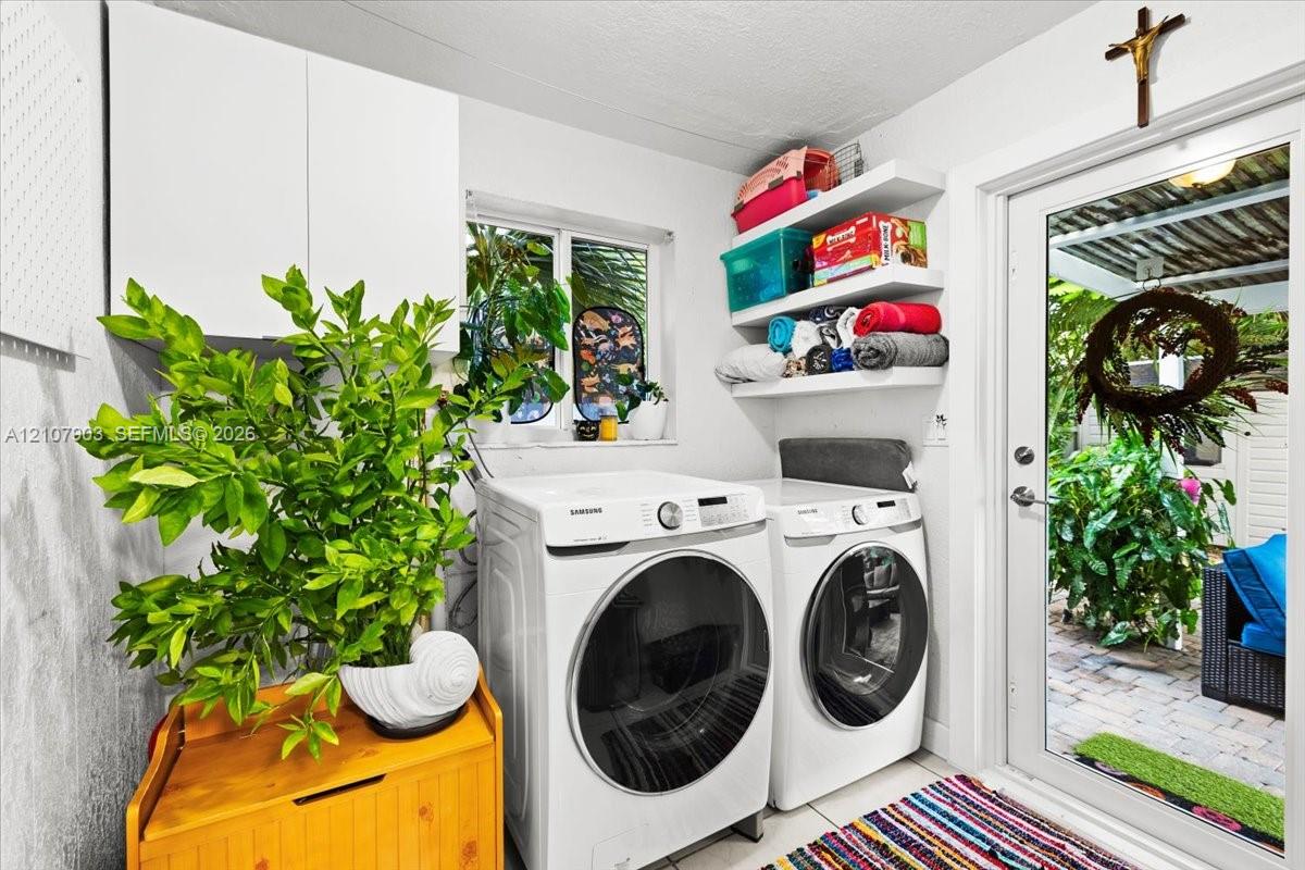 Laundry area featuring white cabinetry, tiered wall-mounted shelving, and a glass-paneled exterior door