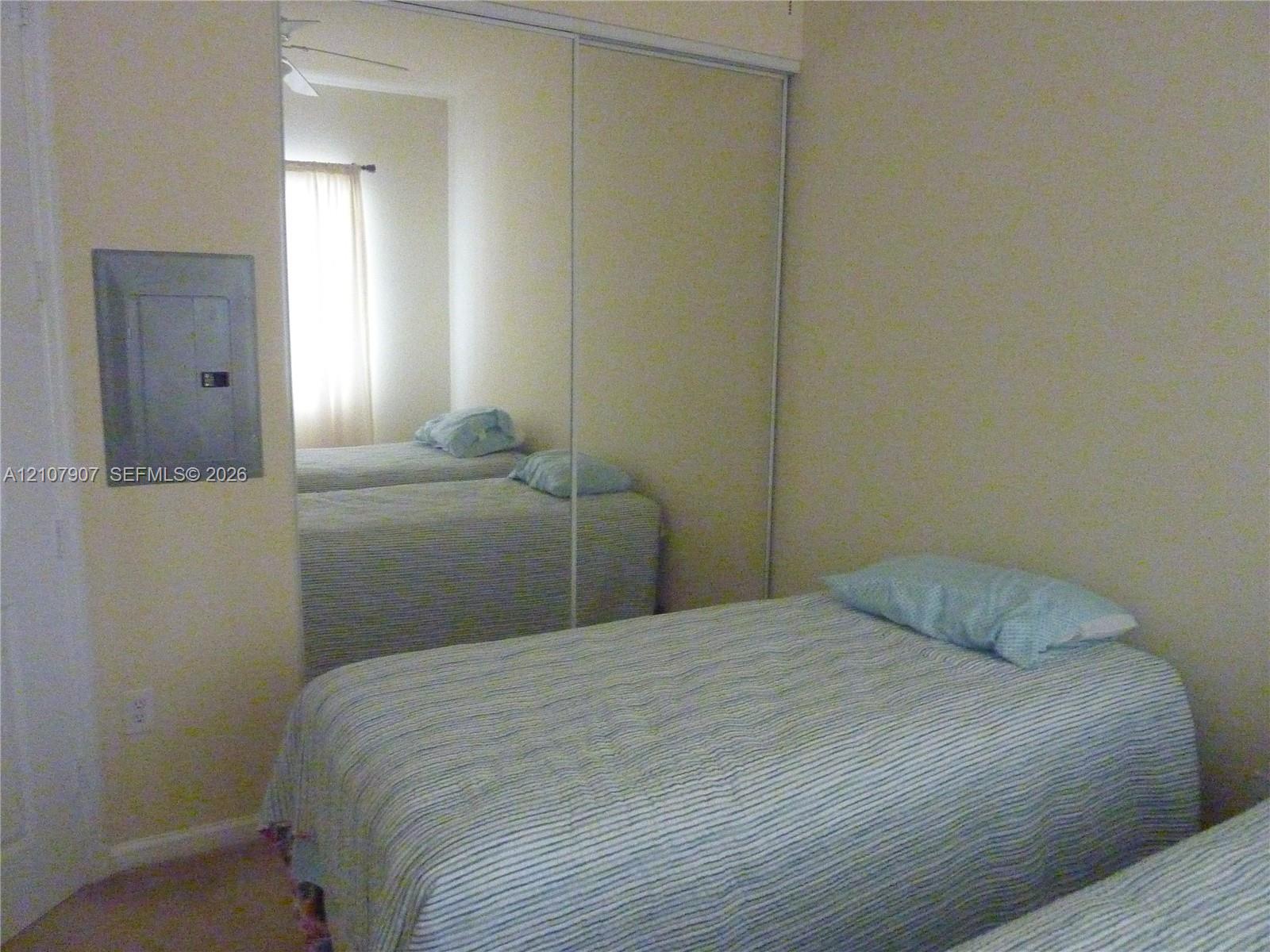 Full-wall sliding mirrored closet doors and neutral wall finishes