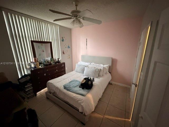 Bedroom featuring ceramic tile flooring, vertical window blinds, and a ceiling fan with integrated lighting