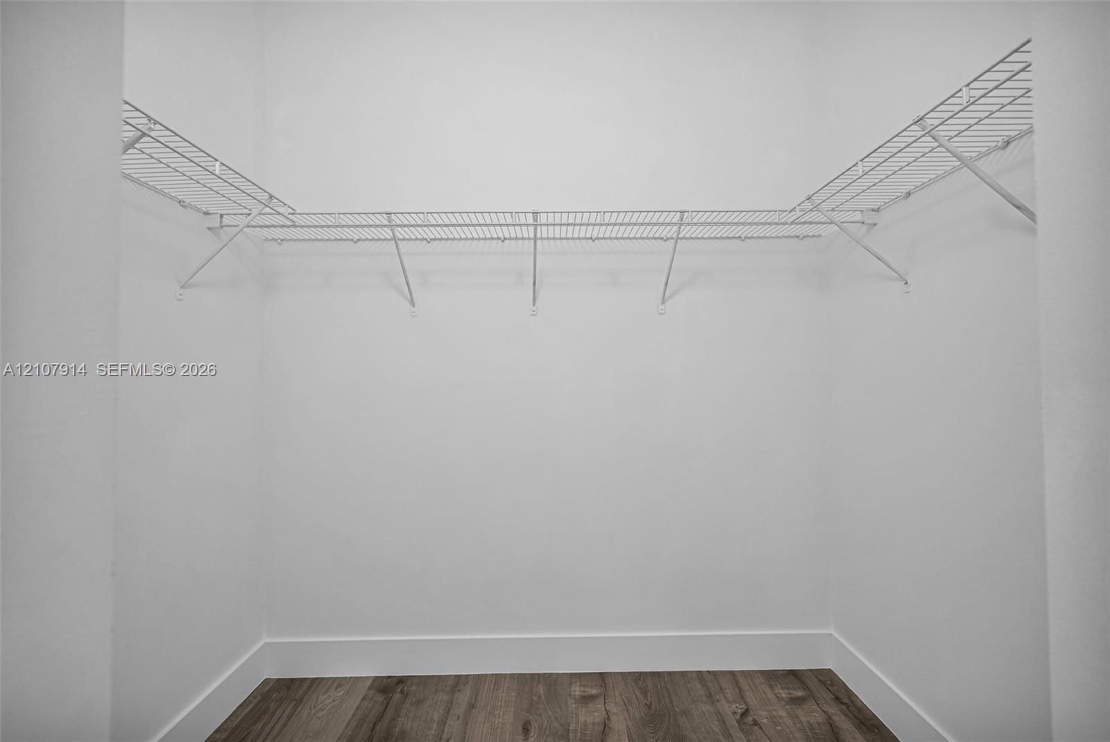 Storage area featuring wood-finish flooring and integrated white wire shelving