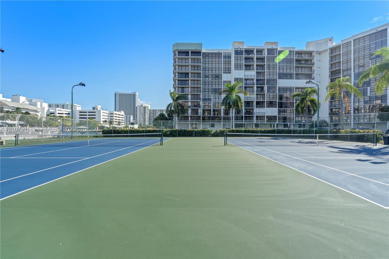 Multi-court tennis facility featuring high-tension perimeter fencing and integrated court lighting Multi-court tennis facility featuring high-tension perimeter fencing and integrated court lighting