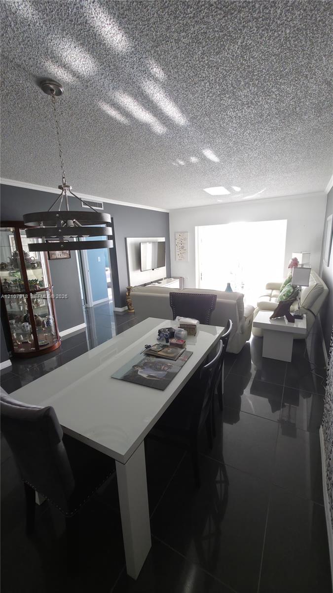 Polished tile flooring, recessed lighting, and a multi-tier metal chandelier fixture