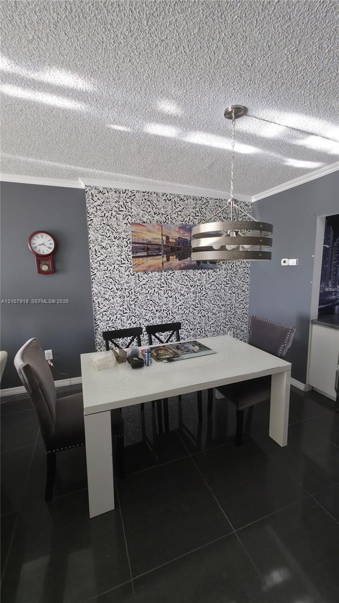 Textured ceiling, accent wall with patterned finish, and industrial-style metal drum pendant light over large-format tile flooring