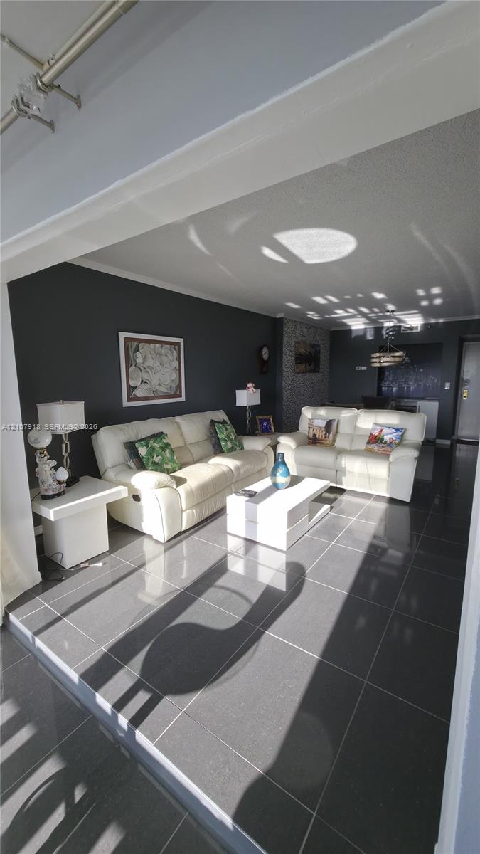 Large-format tile flooring, textured ceiling, and a prominent feature wall with masonry accents Large-format tile flooring, textured ceiling, and a prominent feature wall with masonry accents