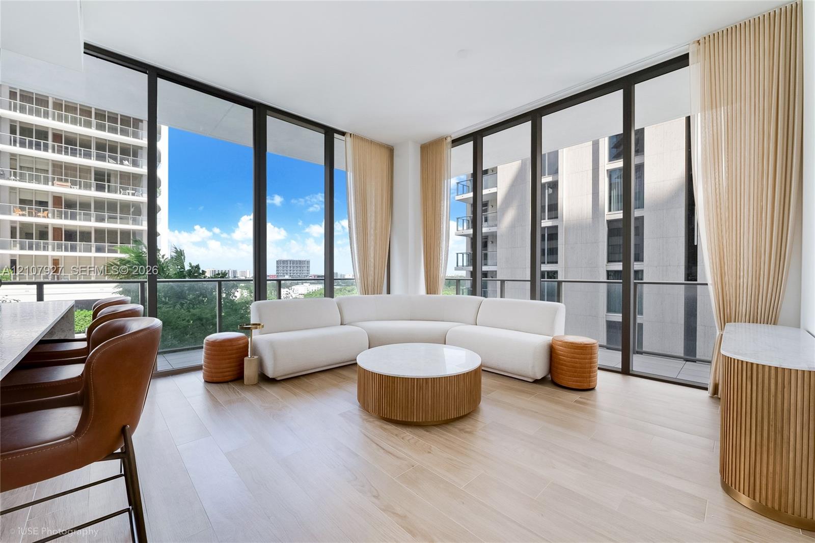 Floor-to-ceiling glass windows, wide-plank wood-finish flooring, and a private balcony with glass railing Floor-to-ceiling glass windows, wide-plank wood-finish flooring, and a private balcony with glass railing