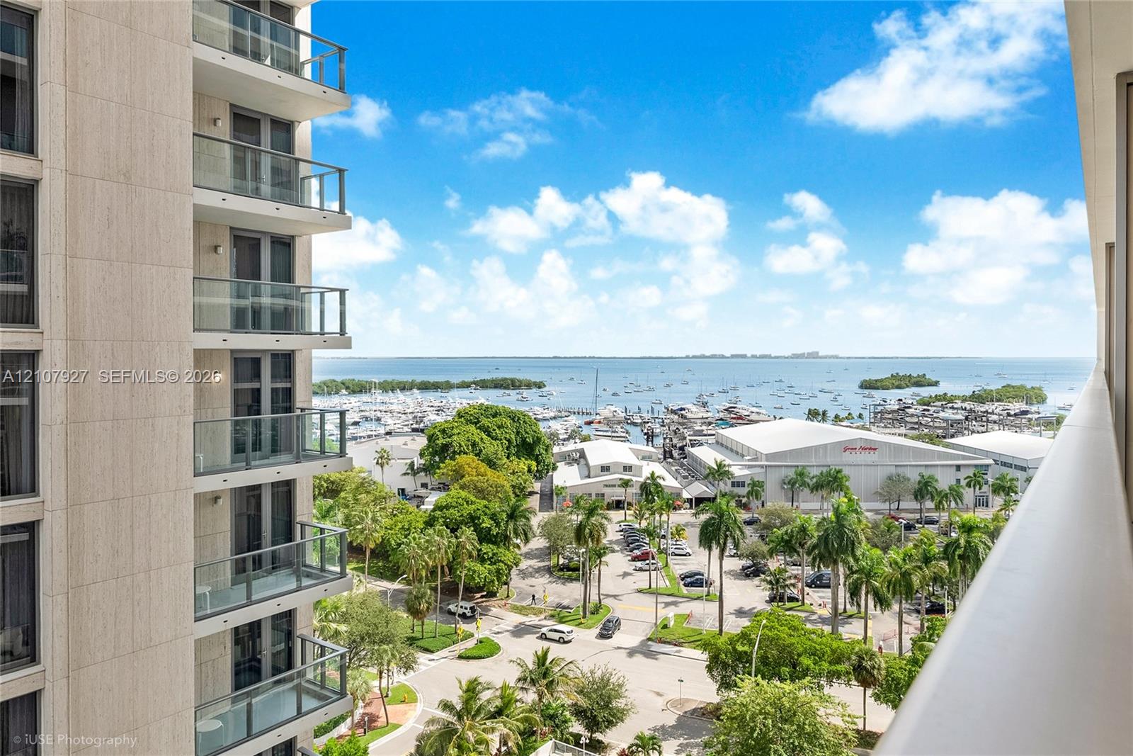 High-rise balcony featuring glass railings, floor-to-ceiling windows, and panoramic water and marina scenery High-rise balcony featuring glass railings, floor-to-ceiling windows, and panoramic water and marina scenery