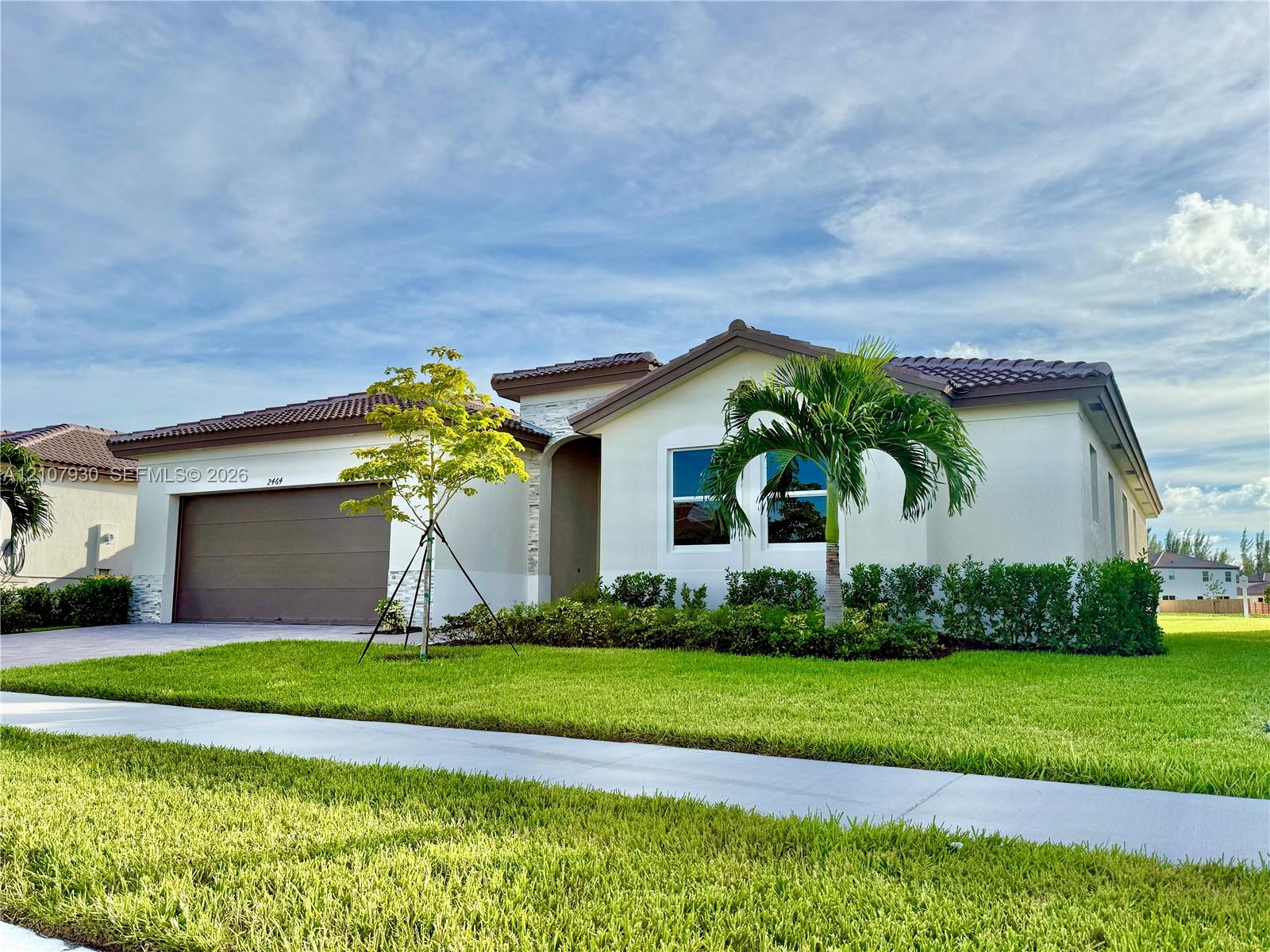 Single-story exterior featuring a tile roof, light-toned stucco facade, stone masonry accents, multi-car garage, and manicured landscaping Single-story exterior featuring a tile roof, light-toned stucco facade, stone masonry accents, multi-car garage, and manicured landscaping