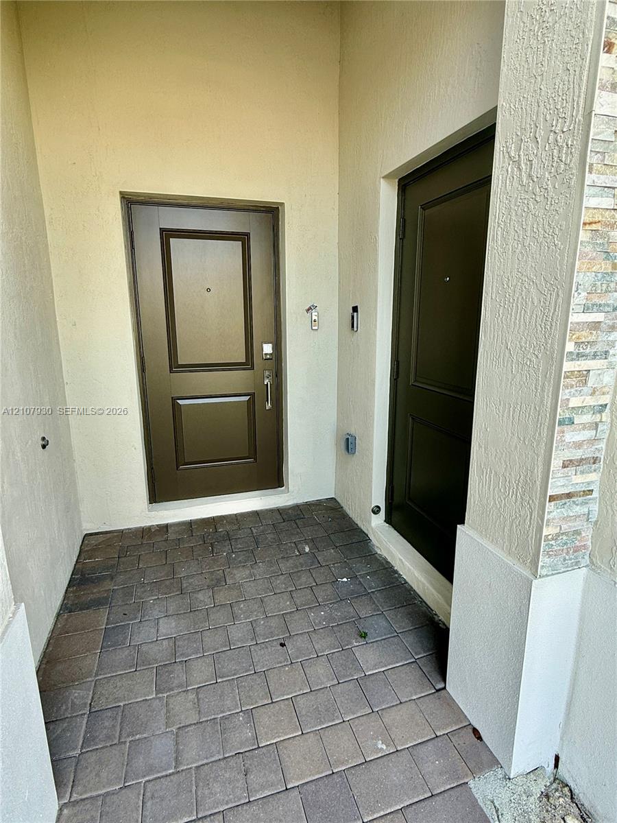Covered entryway featuring paver flooring, dual paneled doors, and stacked stone exterior detailing Covered entryway featuring paver flooring, dual paneled doors, and stacked stone exterior detailing