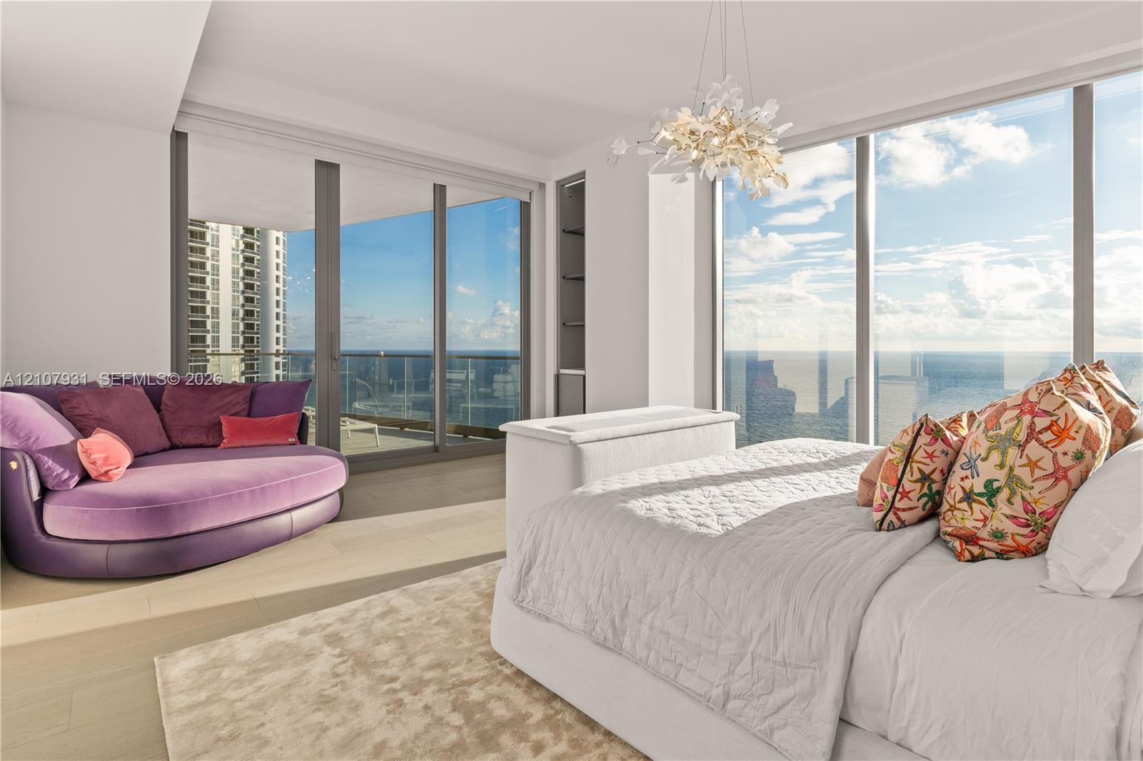 Floor-to-ceiling glass windows, recessed display shelving, wood-finish flooring, integrated ceiling light fixture, and sliding glass doors opening to a balcony