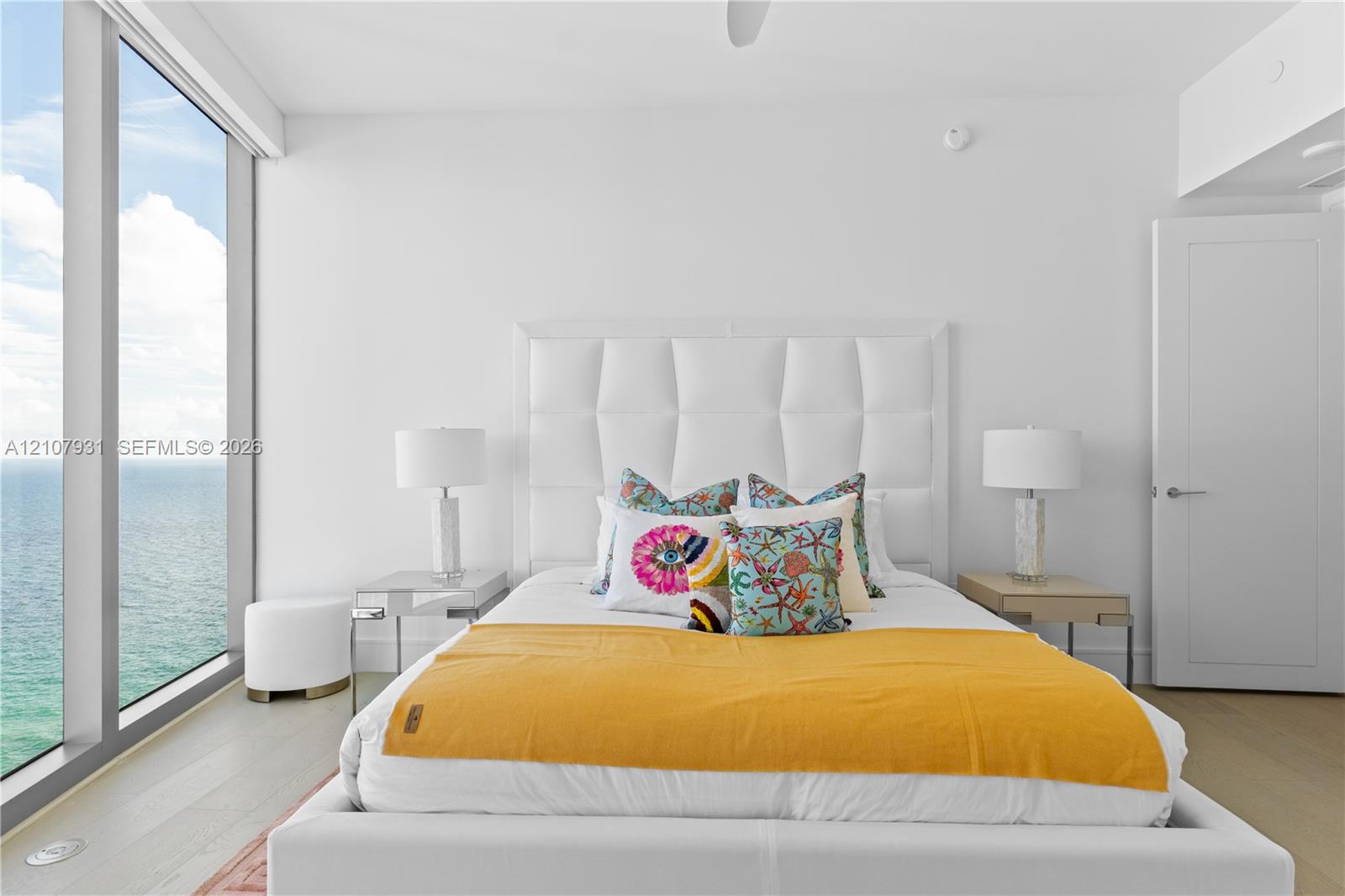 Floor-to-ceiling windows, wood-finish flooring, and white interior finishes
