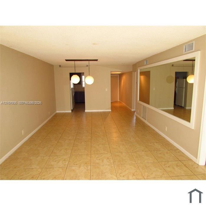 Interior space featuring tile flooring, a large wall-mounted mirror, and dual spherical pendant lighting