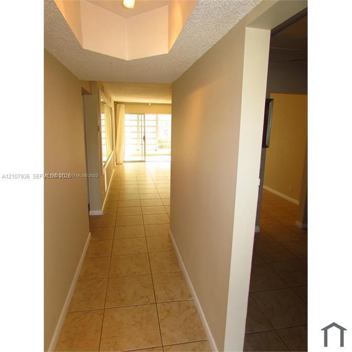 Ceramic tile flooring, recessed ceiling accent, and sliding glass doors