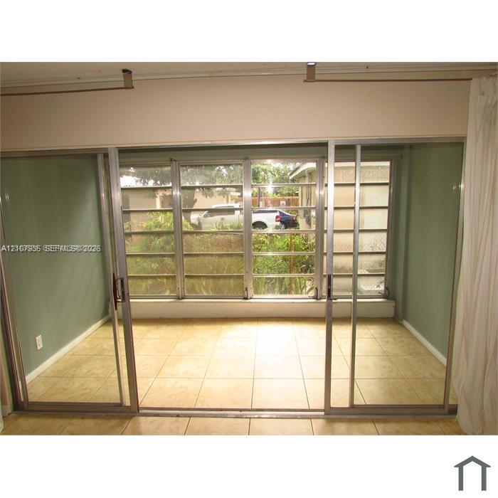 Floor-to-ceiling sliding glass doors with metallic frames and neutral ceramic tile flooring