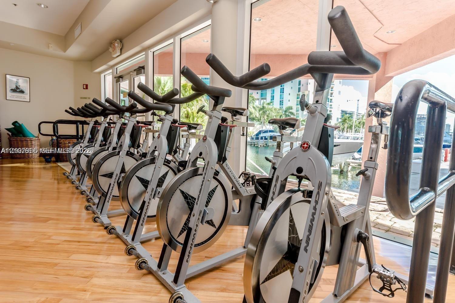 Fitness center featuring wood-finish flooring, floor-to-ceiling windows, and recessed lighting