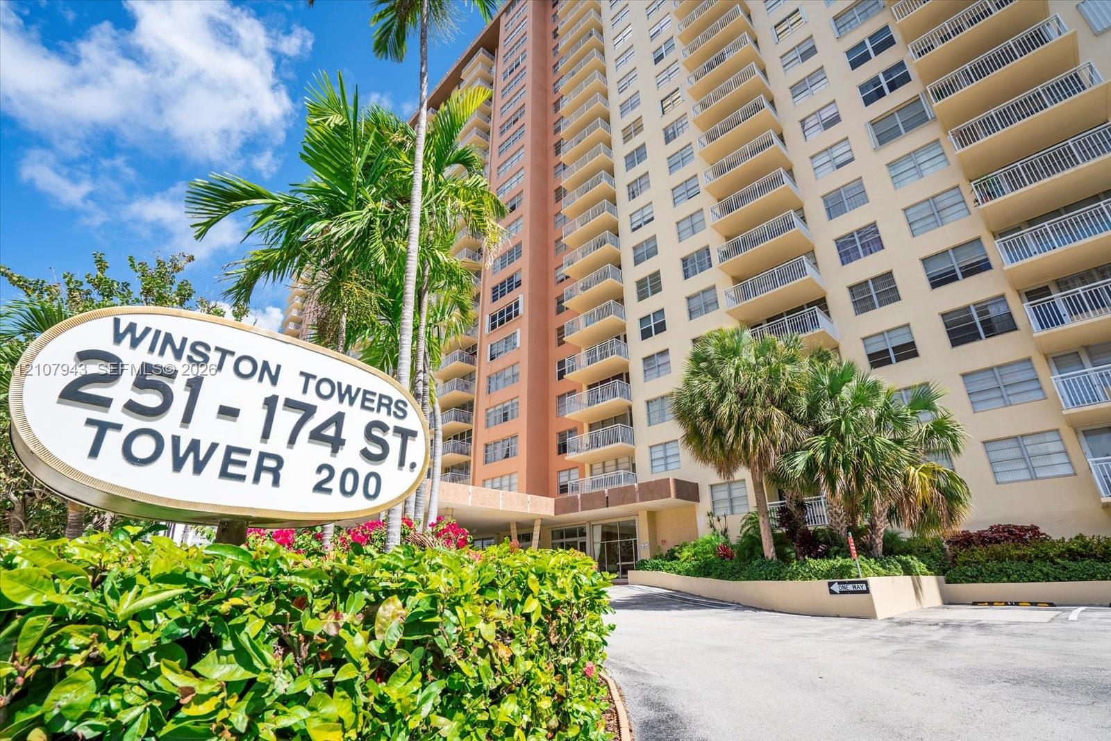 High-rise residential exterior featuring private balconies, masonry construction, and established landscaping