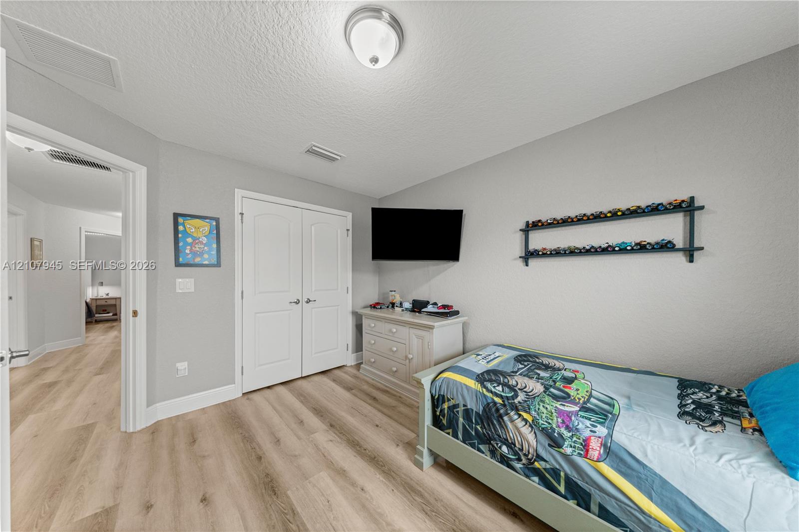 Wood-finish flooring, double-panel interior closet doors, and flush-mount ceiling lighting