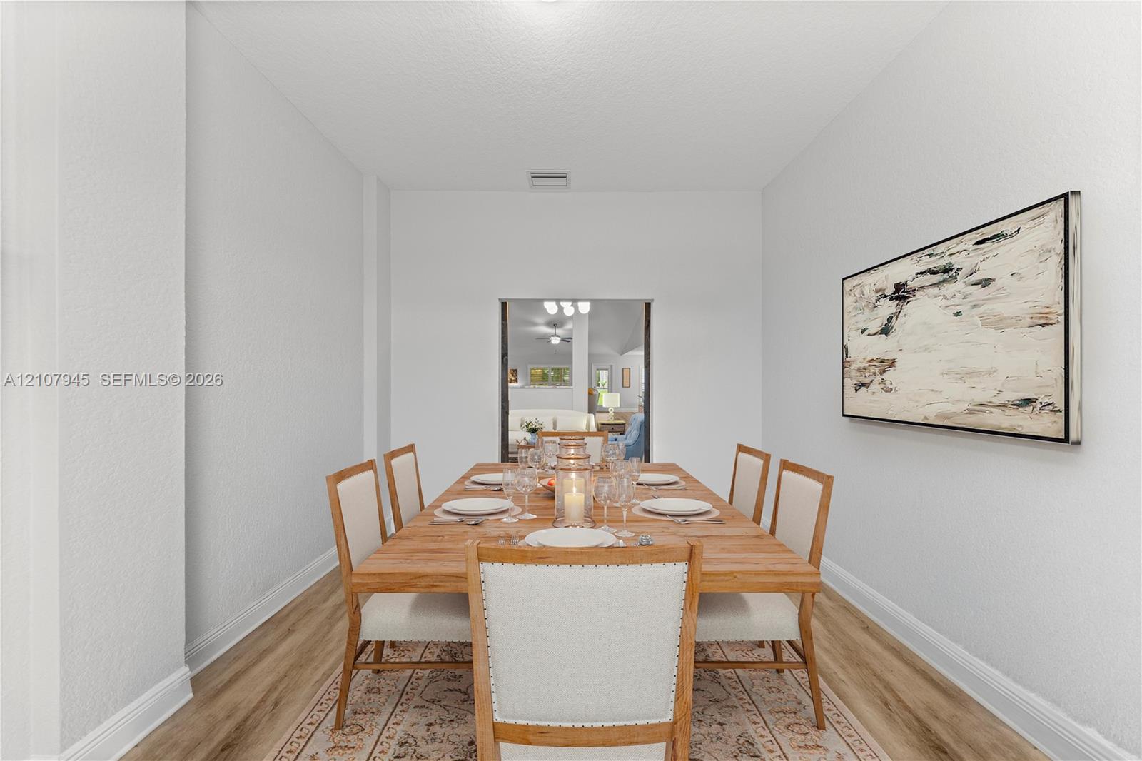 Neutral walls, wood-finish flooring, and a rectangular portal featuring interior architectural trim