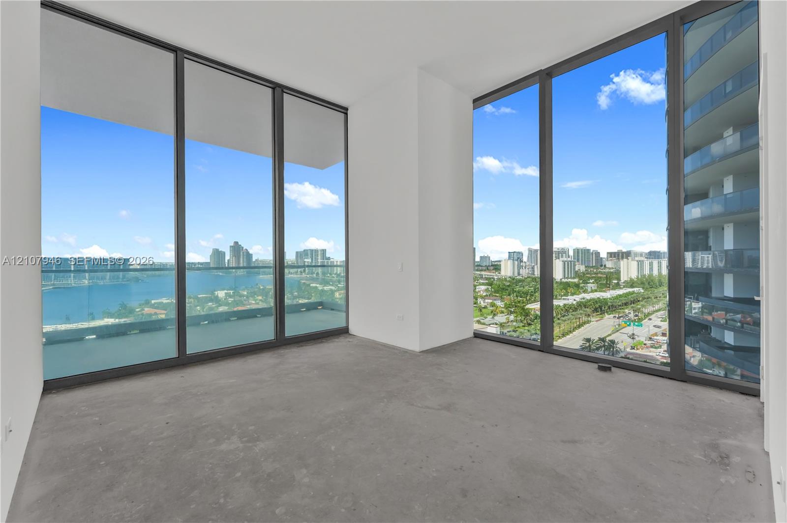 Floor-to-ceiling windows with dark-finish frames, panoramic exterior scenery, and smooth concrete flooring
