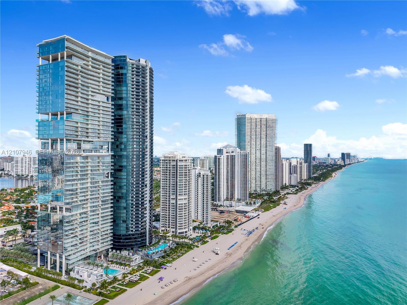 High-rise residential tower featuring glass-paneled exterior, deep recessed balconies, direct oceanfront positioning, and ground-level pool amenities High-rise residential tower featuring glass-paneled exterior, deep recessed balconies, direct oceanfront positioning, and ground-level pool amenities
