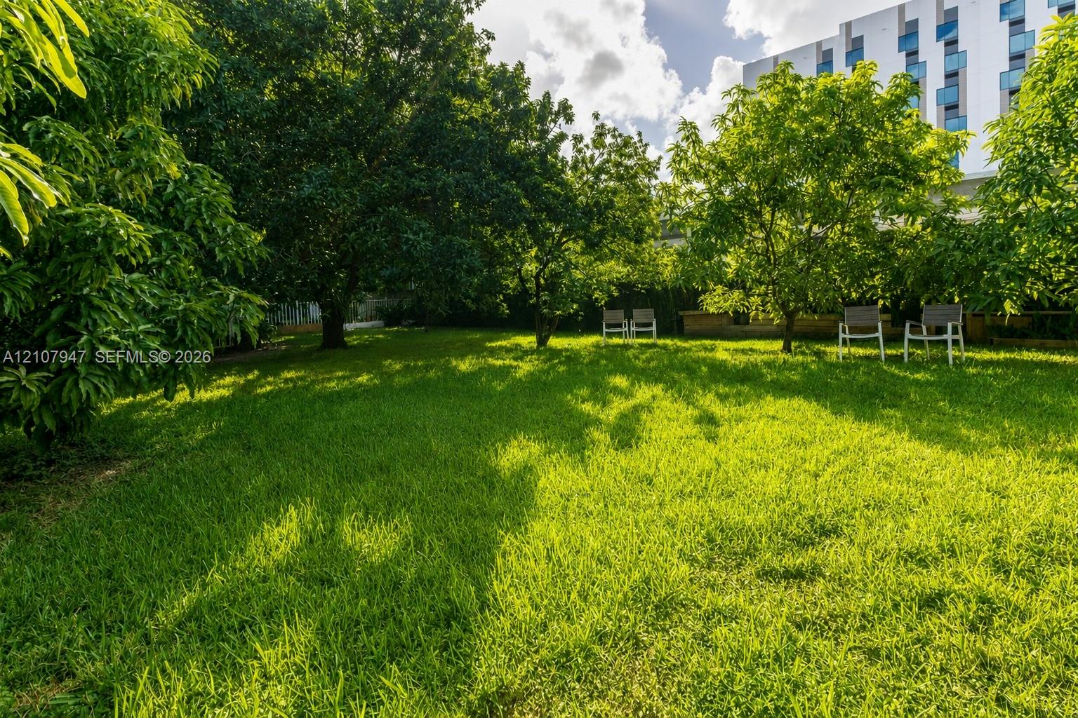 Expansive backyard featuring a lush grass lawn, mature trees, and perimeter landscaping Expansive backyard featuring a lush grass lawn, mature trees, and perimeter landscaping