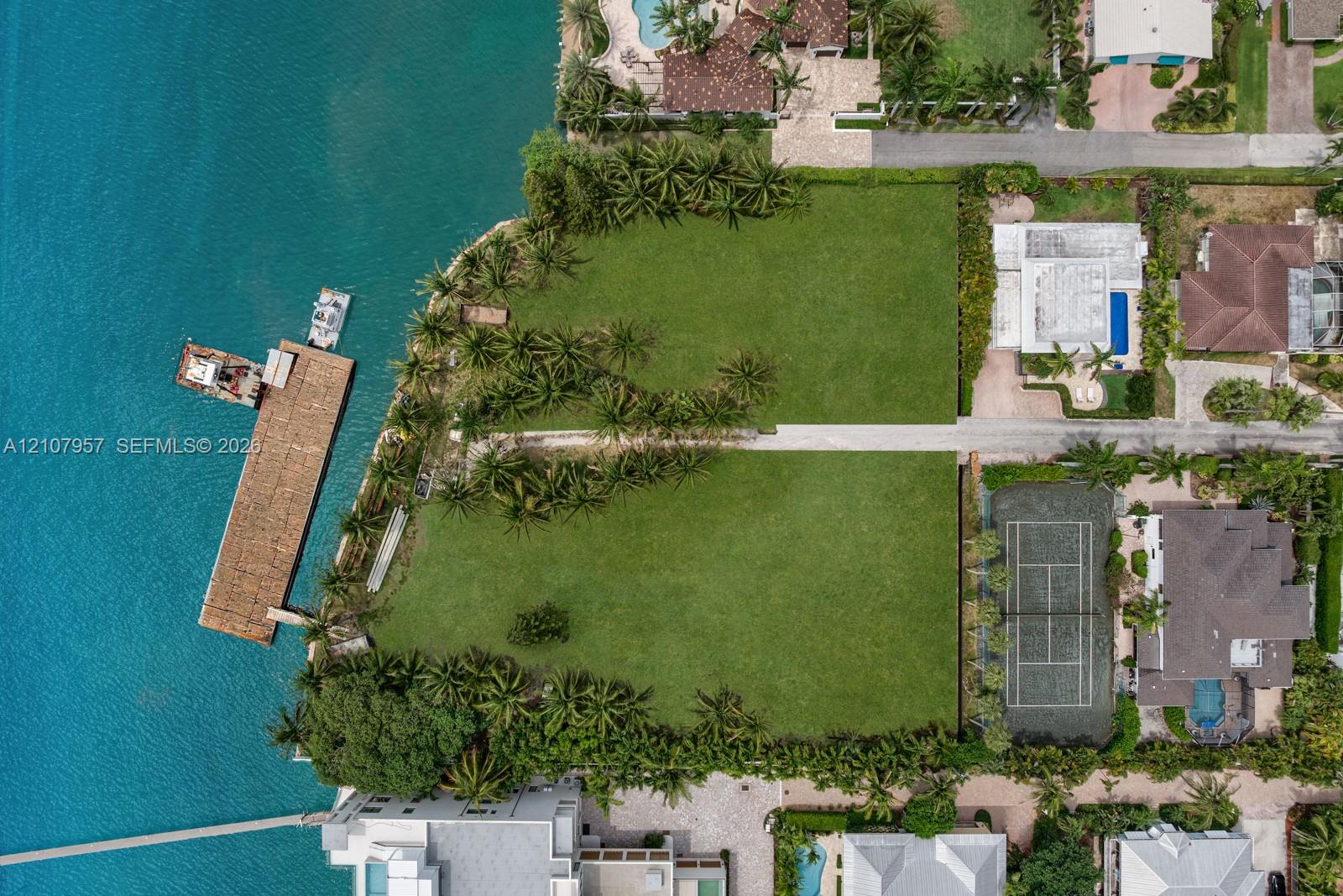 Waterfront parcel featuring extensive shoreline, a private deep-water dock, mature palm landscaping, and expansive green space