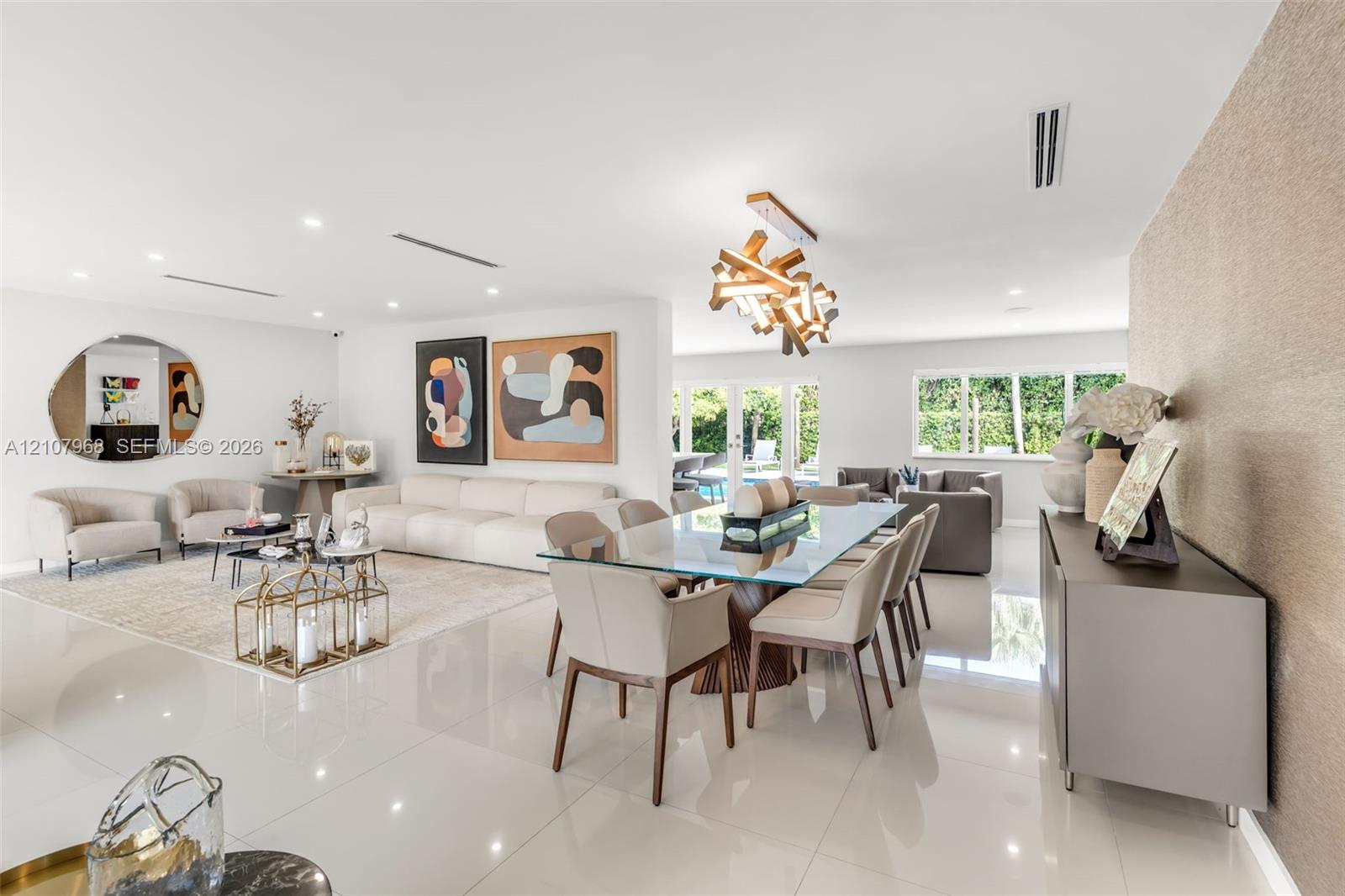 Large-format white tile flooring, modern geometric chandelier, textured feature wall, and multi-panel glass garden doors