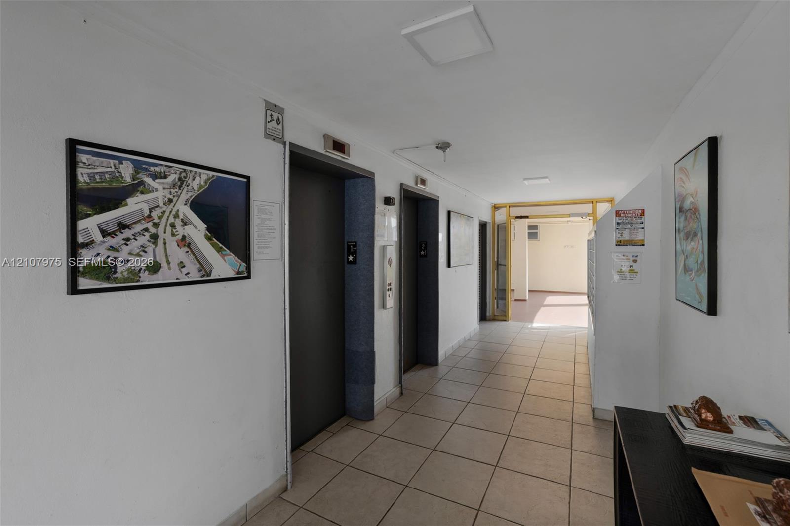 Building lobby area featuring dual elevators, ceramic tile flooring, and integrated mailboxes