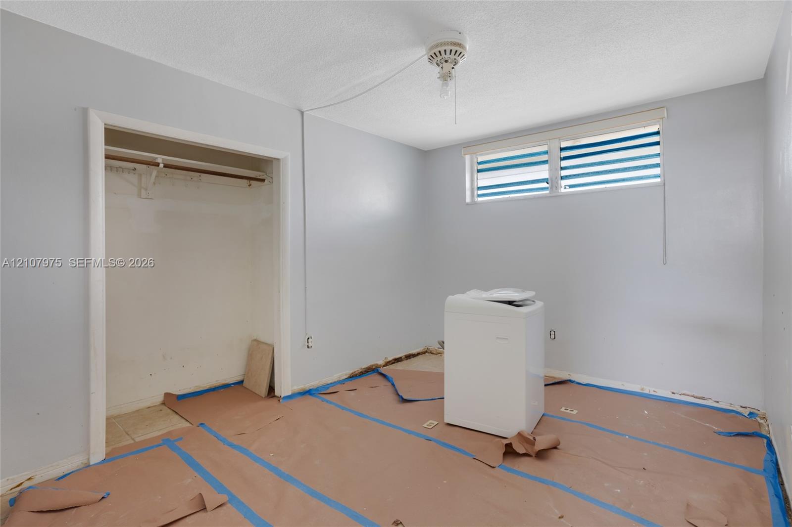 Interior space featuring a reach-in closet with a built-in rod and a high-set horizontal window