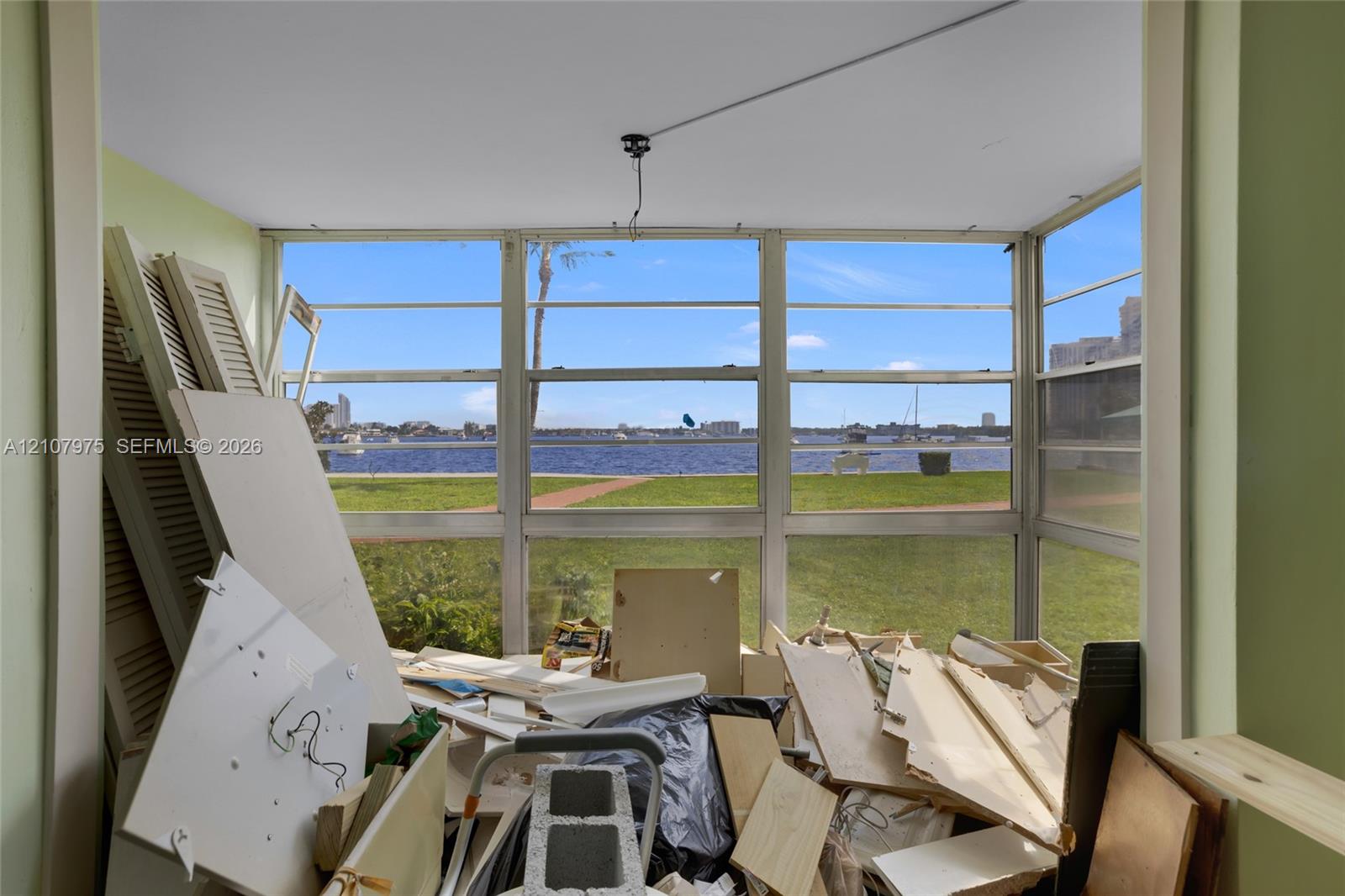 Enclosed sunroom featuring expansive windows and direct water access to the waterway