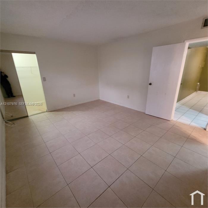 Kitchen featuring white cabinetry, stainless steel appliances, ceramic tile flooring, and a tiled backsplash with decorative accents