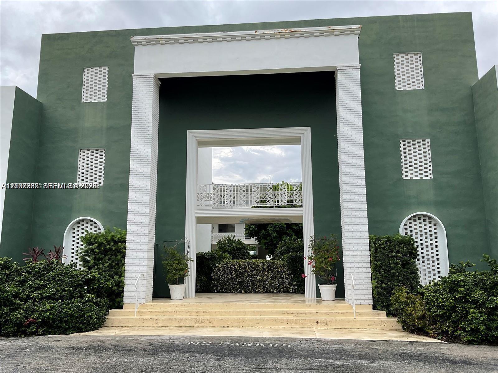 Exterior facade featuring a monumental entrance, prominent white brick columns, geometric lattice detailing, and arched accents