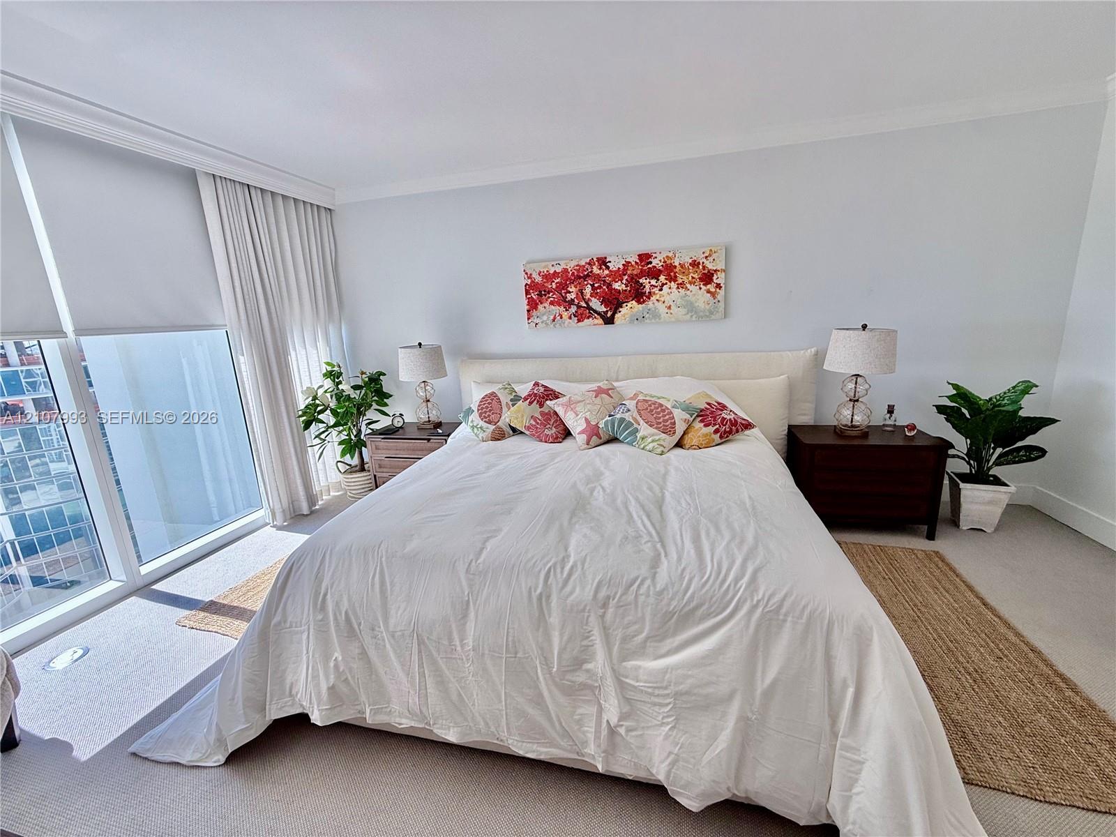 Floor-to-ceiling windows with neutral drapery, crown molding, and wall-to-wall carpeting