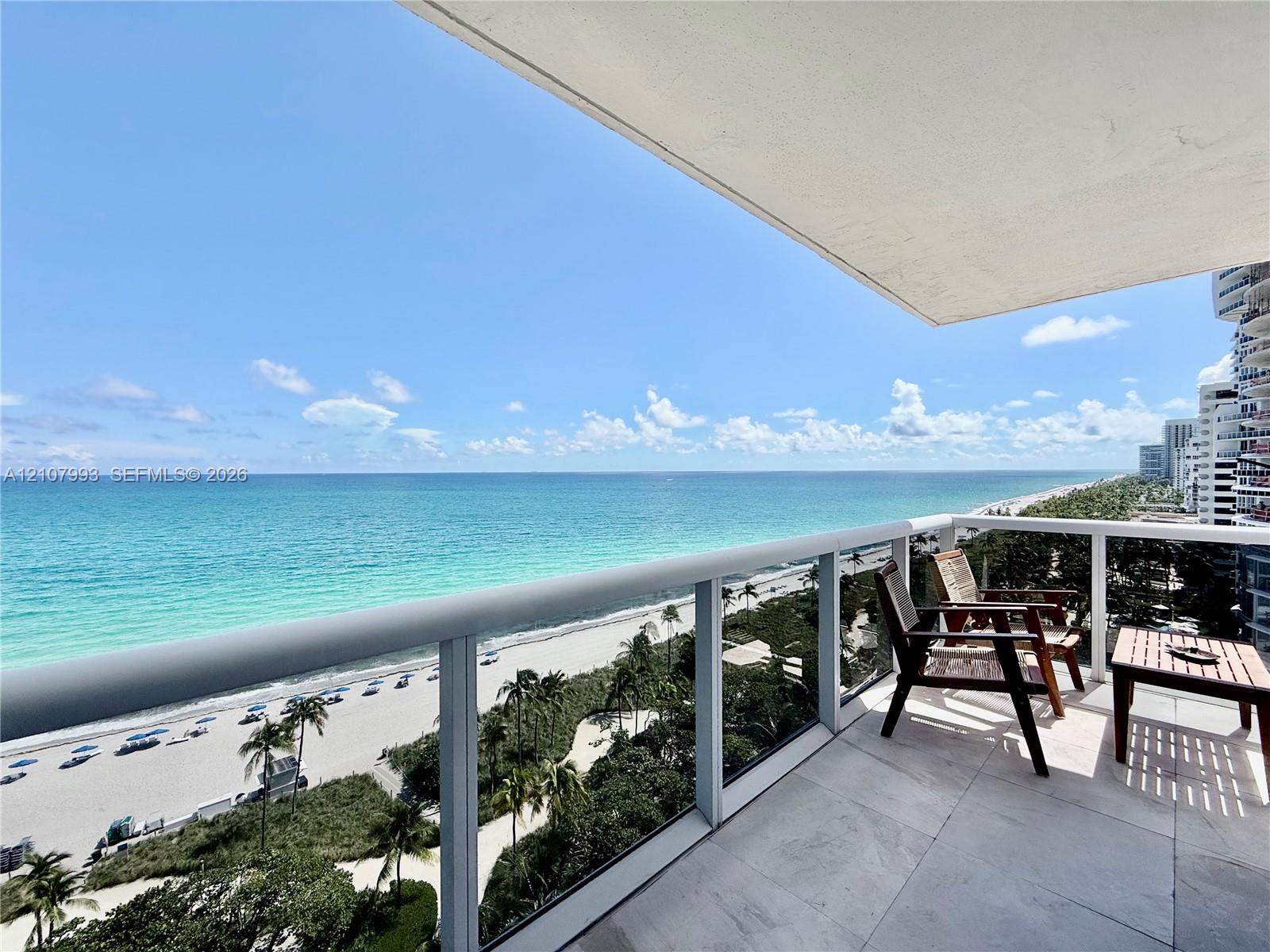 Private balcony featuring large-format tile flooring and a glass panel railing with a metallic frame