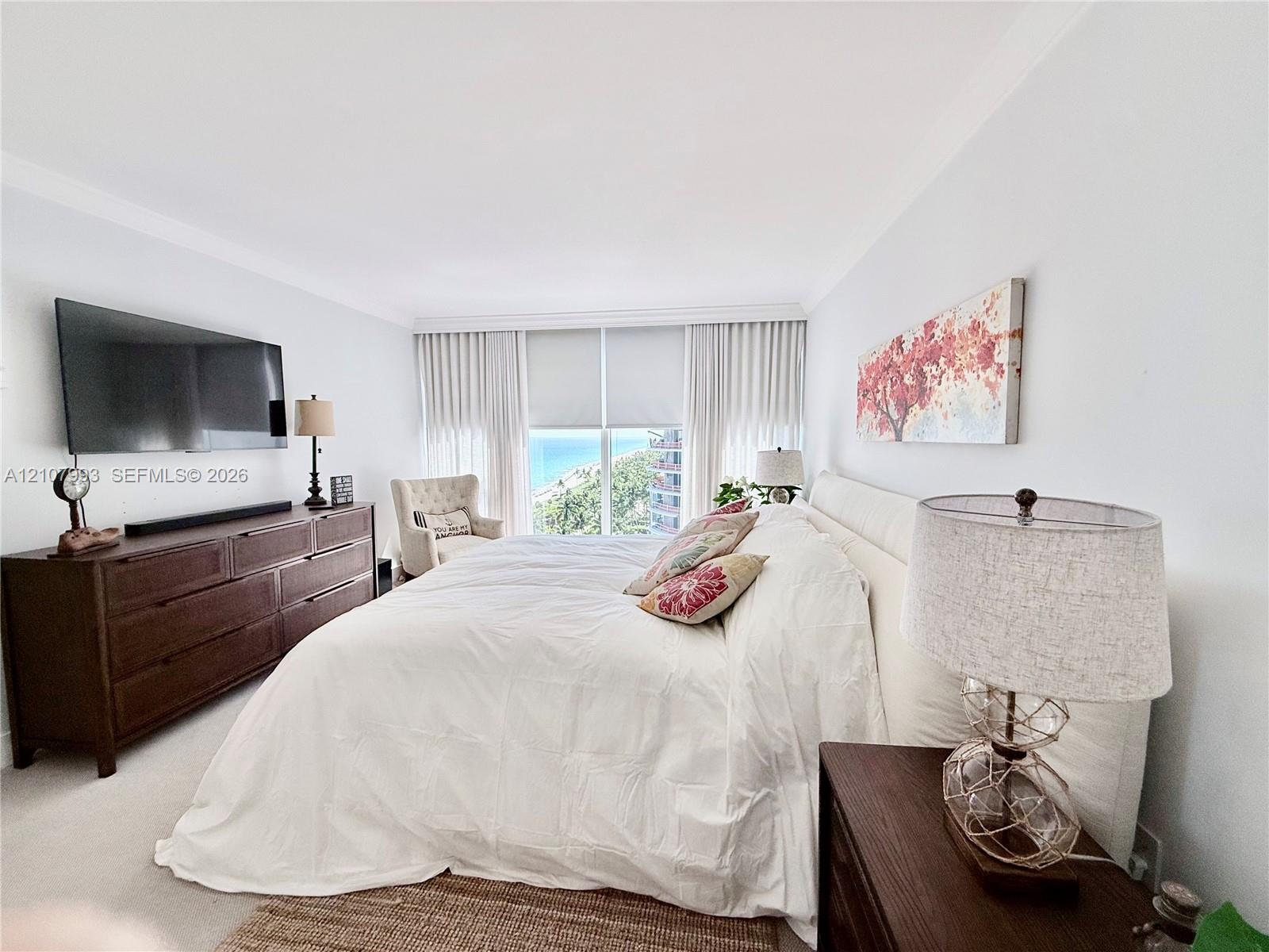 Expansive floor-to-ceiling windows featuring coastal scenery, wall-to-wall carpeting, and neutral paint palette
