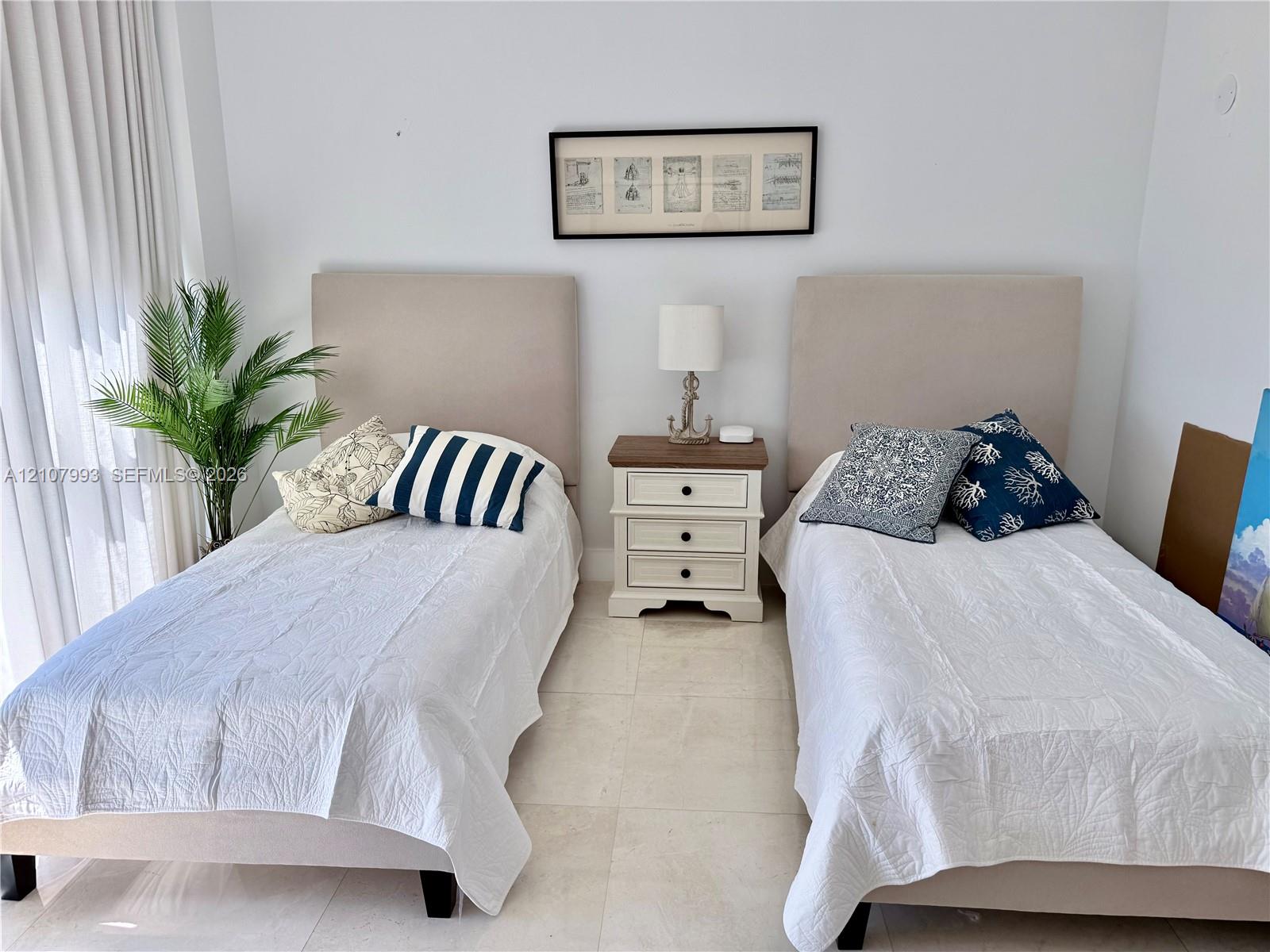 Neutral-toned stone flooring and floor-to-ceiling drapery