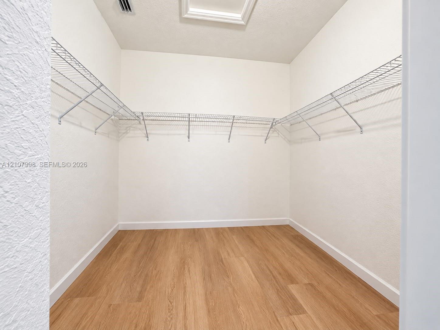 Storage space featuring wood-finish flooring and integrated wire shelving