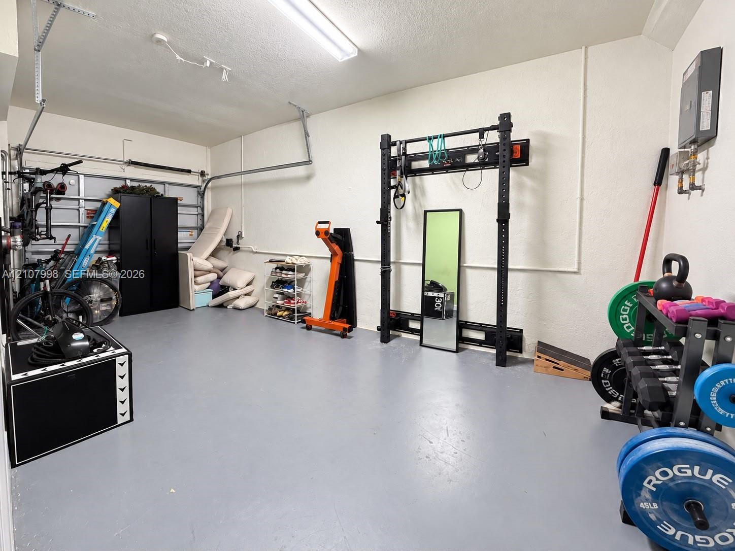 Two-car garage featuring a smooth-finish floor, textured walls, and overhead lighting
