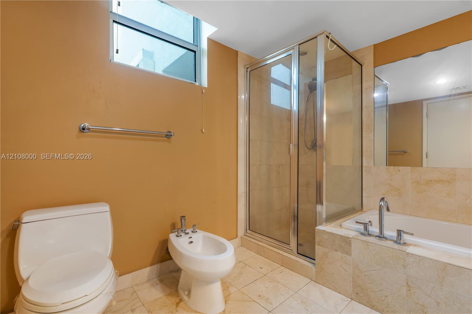 Bathroom featuring a glass-enclosed shower, a deep-set soaking tub with stone tile surround, a bidet, and large-format tile flooring