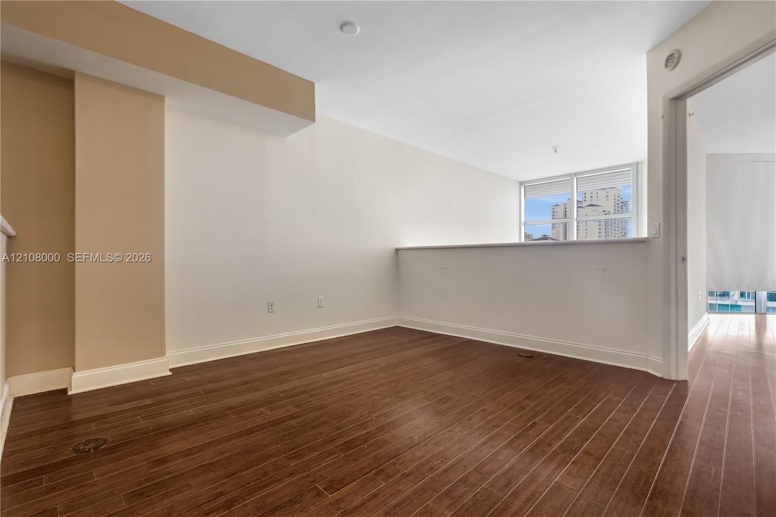Interior space featuring wood-finish flooring, a half-height partition wall, and large windows