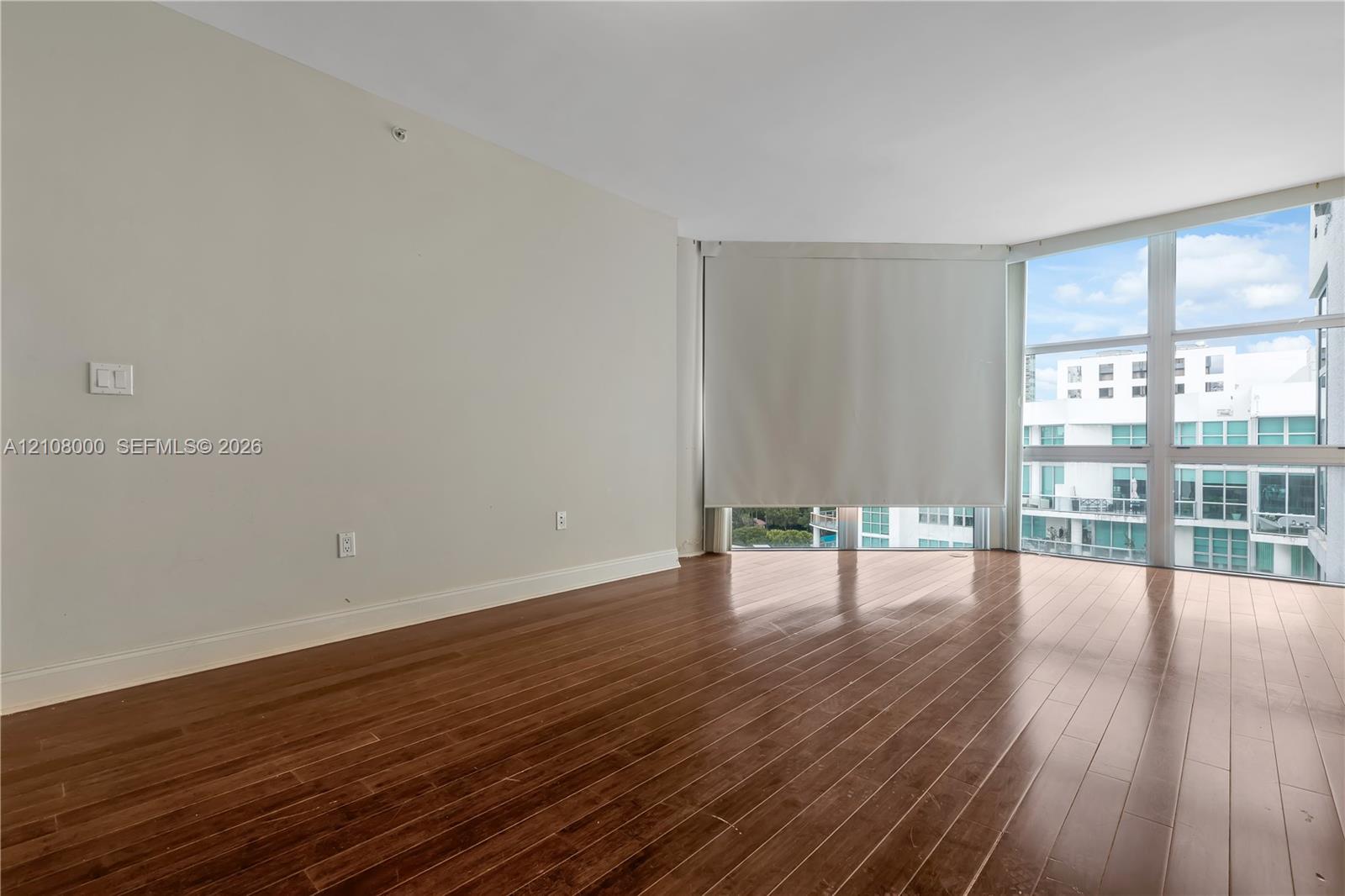 Interior space featuring floor-to-ceiling windows, wood-finish flooring, and neutral wall tones