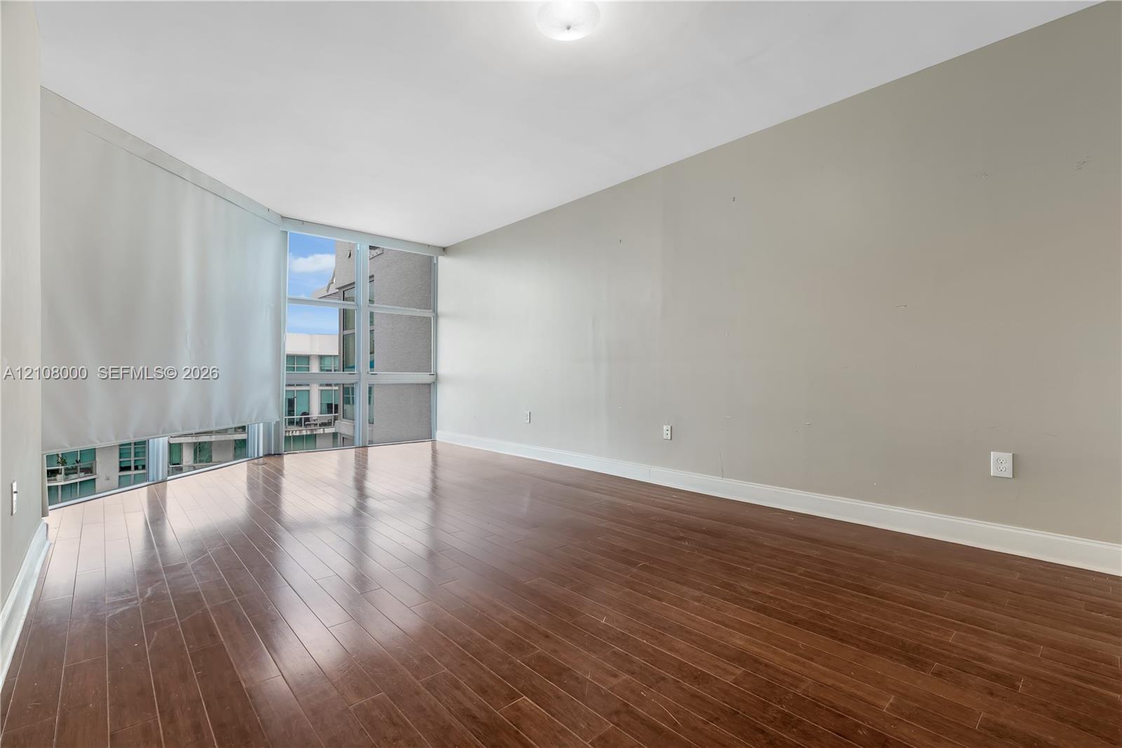 Floor-to-ceiling windows, wood-finish flooring, and recessed ceiling lighting