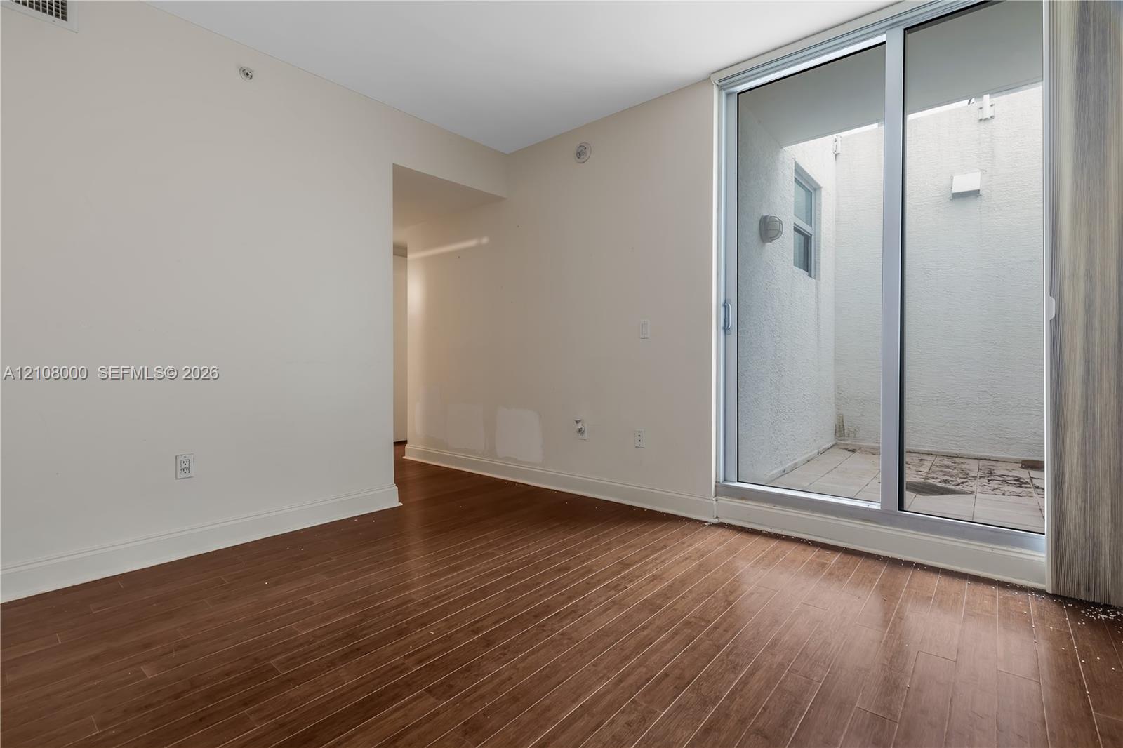 Wood-finish flooring, sliding glass door, and private exterior patio space