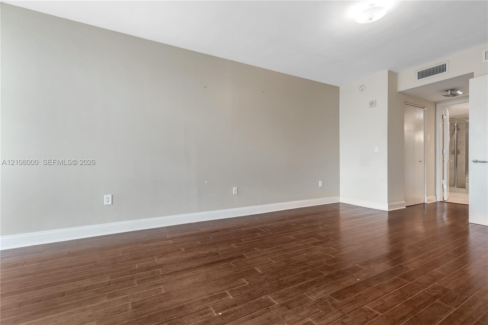Interior space featuring wood-finish flooring, neutral wall paint, and overhead flush-mount lighting