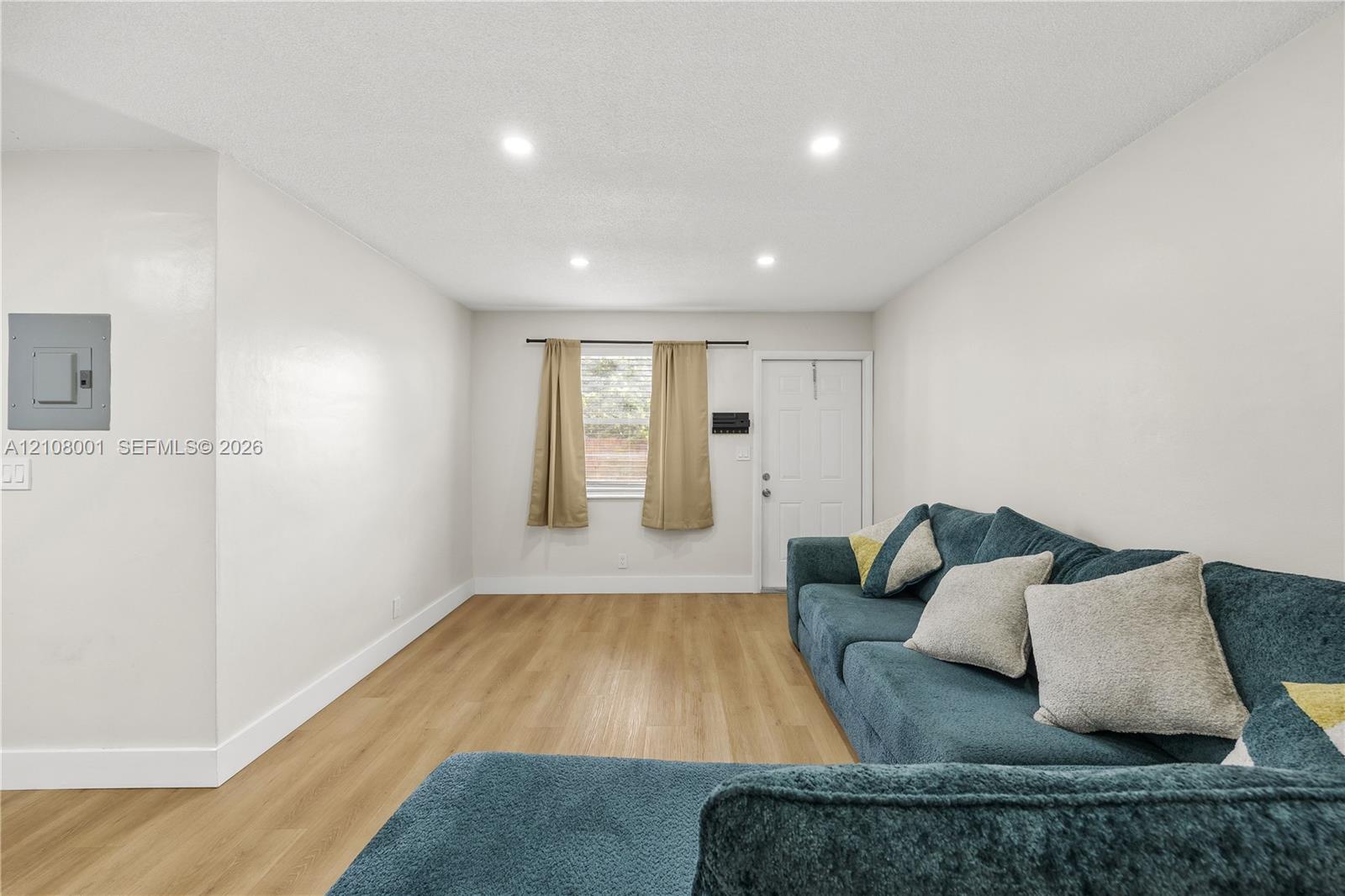 Interior space featuring recessed lighting, wood-finish flooring, and a six-panel entry door