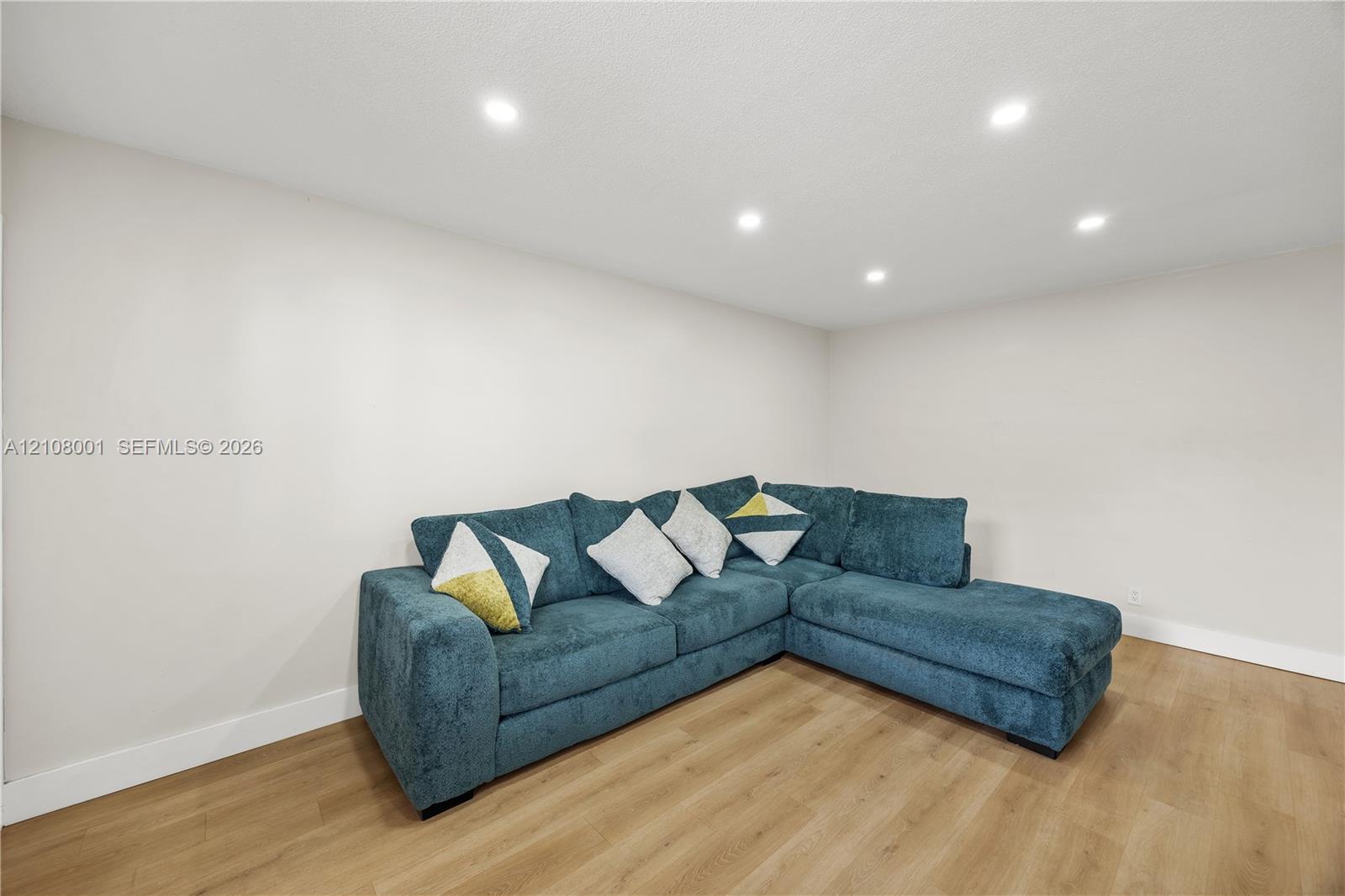 Neutral wall paint, wood-finish flooring, and recessed ceiling lighting