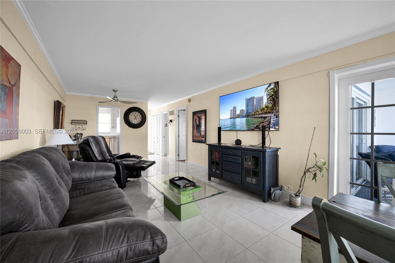 Living area featuring light-toned tile flooring, recessed ceiling lighting, a dedicated ceiling fan, and multi-pane glass door paneling