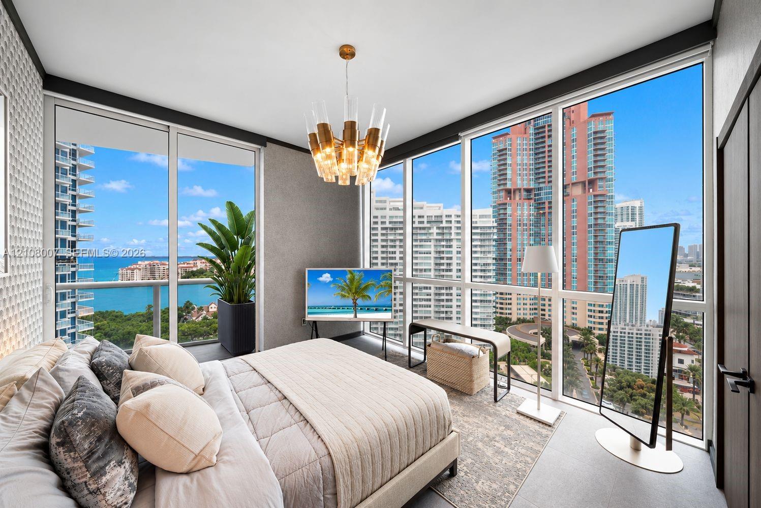 Floor-to-ceiling windows, sculptural multi-tier chandelier, textured accent wall, and neutral large-format tile flooring