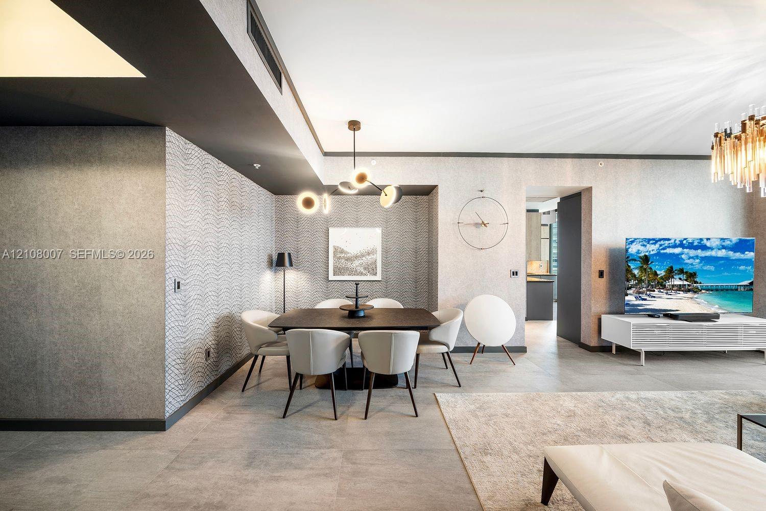 Textured wall coverings, large-format tile flooring, recessed ceiling lighting, and multi-arm geometric chandeliers