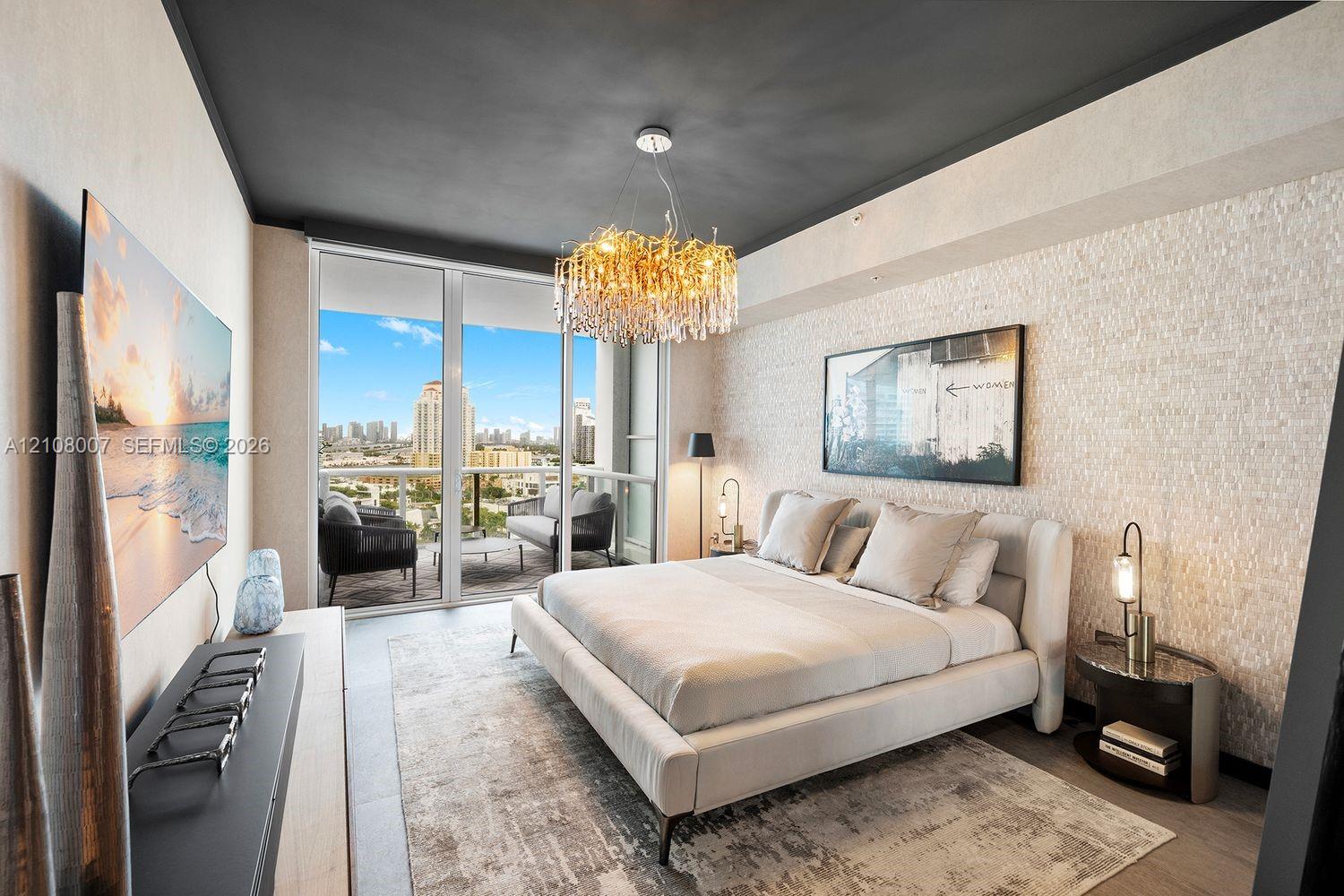 Textured stone accent wall, floor-to-ceiling glass paneling, private balcony, and decorative crystal chandelier